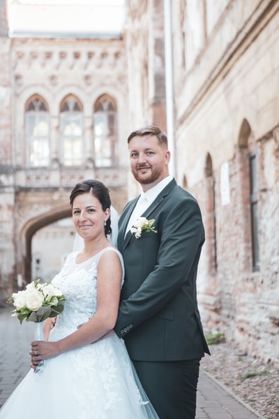 In the black suit men and women wear white wedding dress
